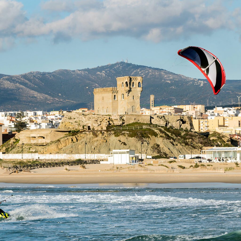 Man practicing kitesurfing on the beach of Tarifa, Spain.